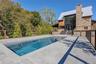 Swimming pool with a patio and view of scattered trees