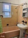 Bathroom featuring decorative backsplash, tile walls, and shower / bathtub combination with curtain