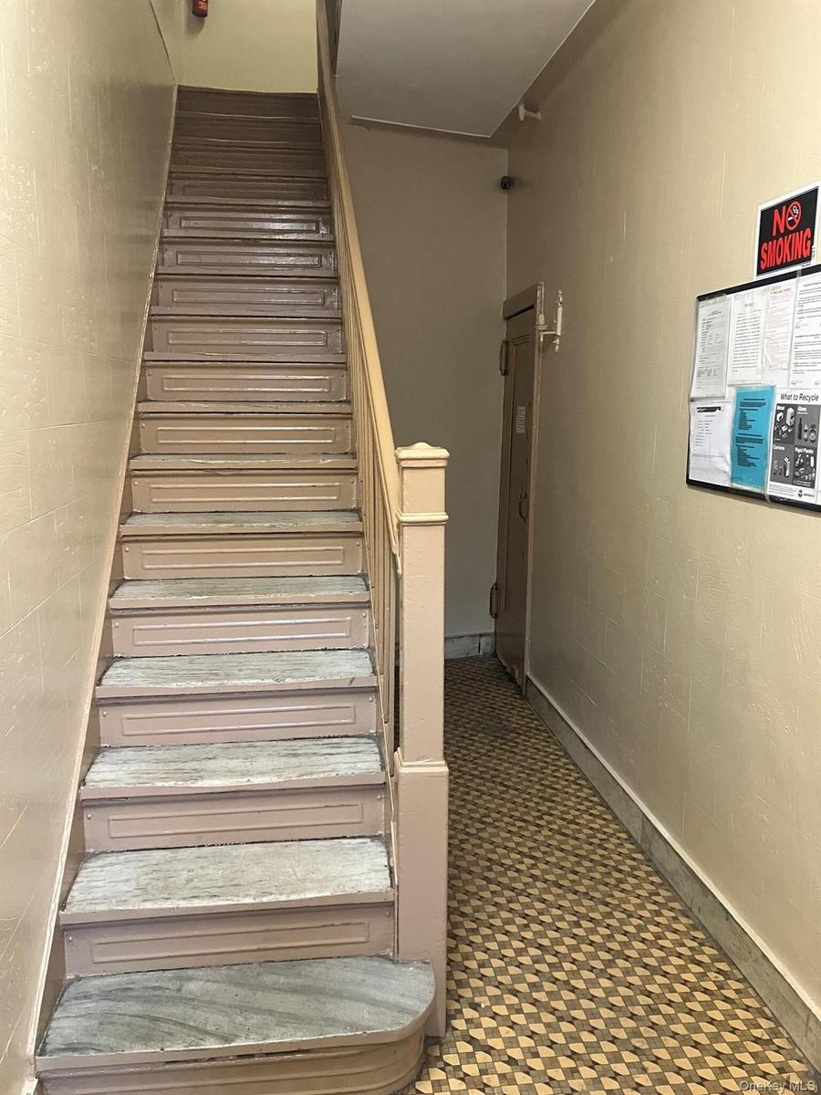 Staircase featuring concrete block wall