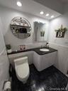 Bathroom featuring tile walls, a wainscoted wall, vanity, recessed lighting, and radiator