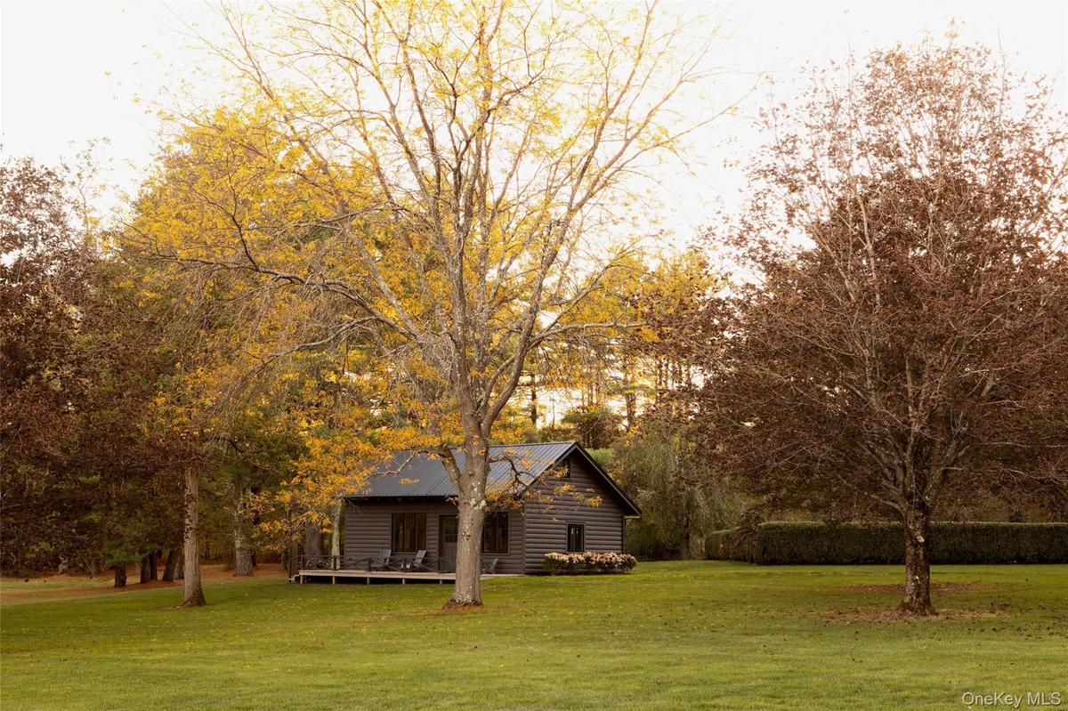 View of grassy yard with a wooden deck