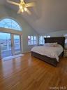 Bedroom with multiple windows, wood finished floors, ceiling fan, and high vaulted ceiling