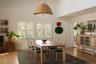 Dining room with light wood-type flooring and a towering ceiling
