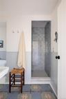 Bathroom with wainscoting, a stall shower, and a decorative wall