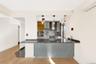 Kitchen featuring a peninsula, tasteful backsplash, a wall mounted AC, hanging light fixtures, and dark stone counters