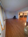 Unfurnished living room featuring light wood finished floors, a wall mounted AC, and an AC wall unit