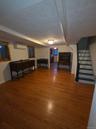 Finished basement featuring hardwood / wood-style floors, stairway, and a wall mounted air conditioner