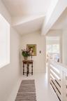 Hallway featuring vaulted ceiling and tile patterned floors