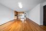 Unfurnished living room with a baseboard radiator, light wood-style flooring, and baseboards