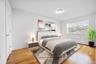 Bedroom featuring light wood finished floors, baseboards, and a baseboard heating unit