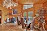 Dining room featuring a wood stove, wooden walls, vaulted ceiling, baseboard heating, and wood ceiling