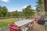 Wooden deck with a lawn, outdoor dining area, and an outdoor hangout area