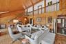 Living area with wooden walls, high vaulted ceiling, stairs, and wooden ceiling