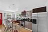 Kitchen with dark countertops, stainless steel appliances, decorative light fixtures, light wood-type flooring, and recessed lighting