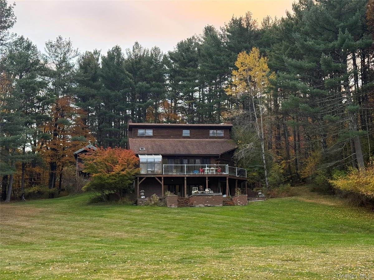 Rear view of house with a yard and a wooden deck