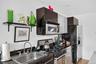 Kitchen with stainless steel appliances, light wood-type flooring, dark stone countertops, glass insert cabinets, and modern cabinets