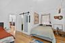 Bedroom with a barn door and light wood finished floors