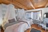 Bedroom with a wooden ceiling with exposed beams and a baseboard heating unit