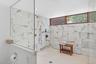 Main first floor full bath with a marble finish shower.