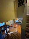 Stairs with wood finished floors and a high ceiling