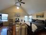 Bedroom featuring hardwood / wood-style floors, multiple windows, high vaulted ceiling, and ceiling fan