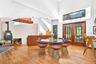 Great Room featuring wood finished floors, a towering ceiling, french doors, a wood stove, and brick wall with fireplace.