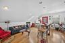 Living area with a skylight, vaulted ceiling, light wood finished floors, and recessed lighting
