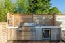 View of patio with area for grilling, wine cooler, and a wooden deck