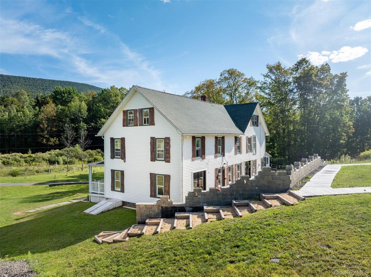 View of front facade featuring a front yard and a chimney