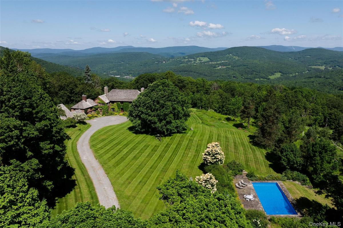 Drone / aerial view of a mountainous background and a pool area