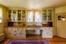 Kitchen featuring wood counters, radiator heating unit, glass insert cabinets, and light wood-type flooring