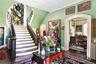 Stairway featuring radiator, hardwood / wood-style floors, arched walkways, baseboards, and ornamental molding