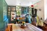 Dining space with an ornate ceiling, light wood finished floors, brick wall, crown molding, and a wood stove