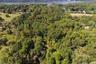 Aerial view of property and surrounding area with a forest and a large body of water