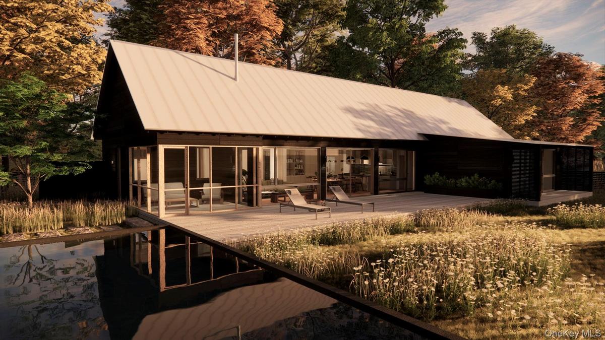 Rear view of house with a patio, a metal roof, and view of wooded area