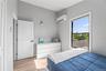 Bedroom with light wood finished floors and a wall mounted AC