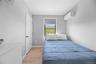 Bedroom with light wood-style floors and an AC wall unit