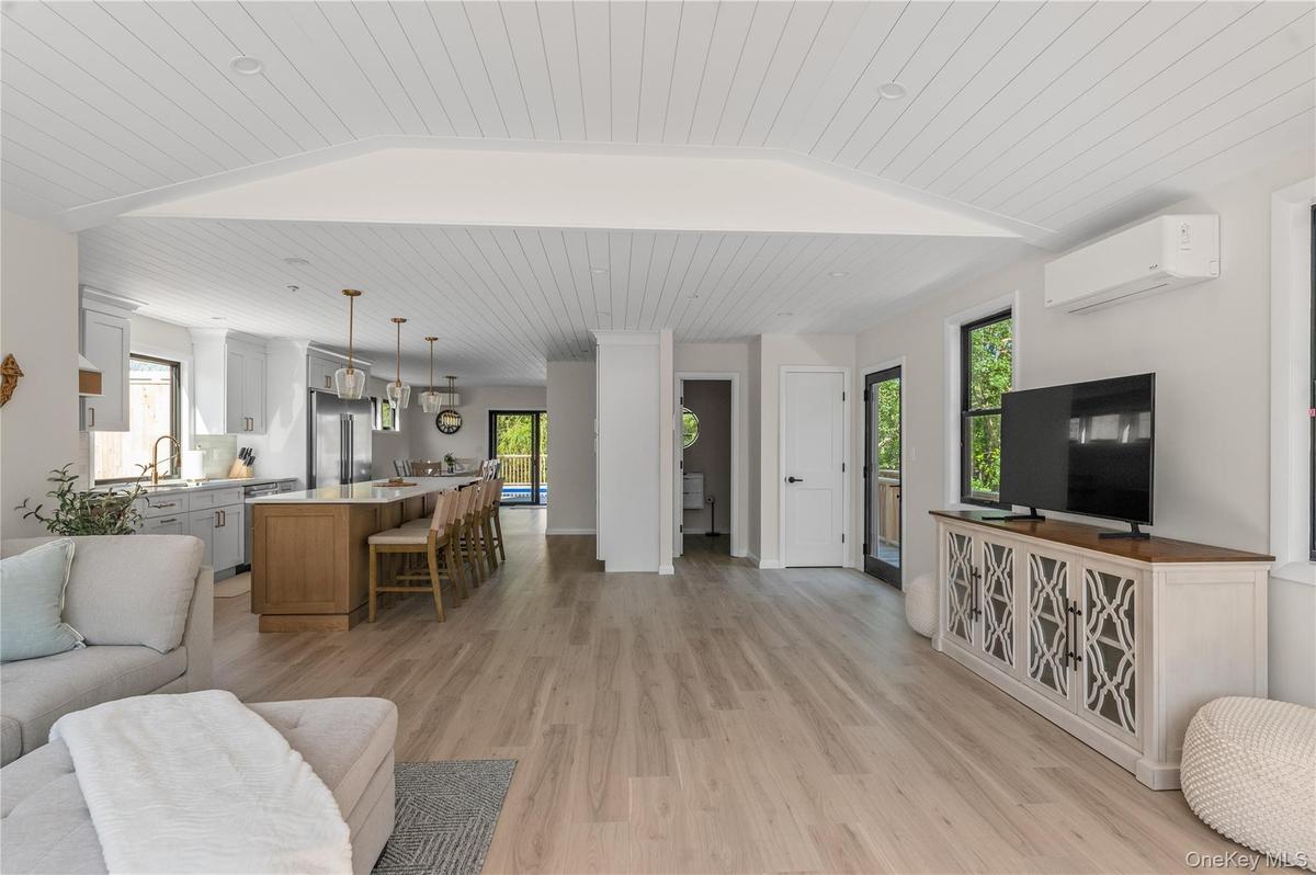 Living area featuring wooden ceiling, an AC wall unit, light wood finished floors, and lofted ceiling