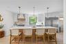 Kitchen featuring decorative backsplash, high end fridge, a kitchen island, light wood-style floors, and a kitchen bar