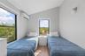 Bedroom featuring vaulted ceiling, wood finished floors, and a wall mounted AC