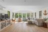 Sunroom with plenty of natural light, a wall unit AC, and lofted ceiling
