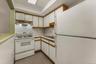 Kitchen featuring sink, white appliances, and white cabinets