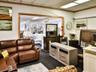 Living room with dark colored carpet and a drop ceiling