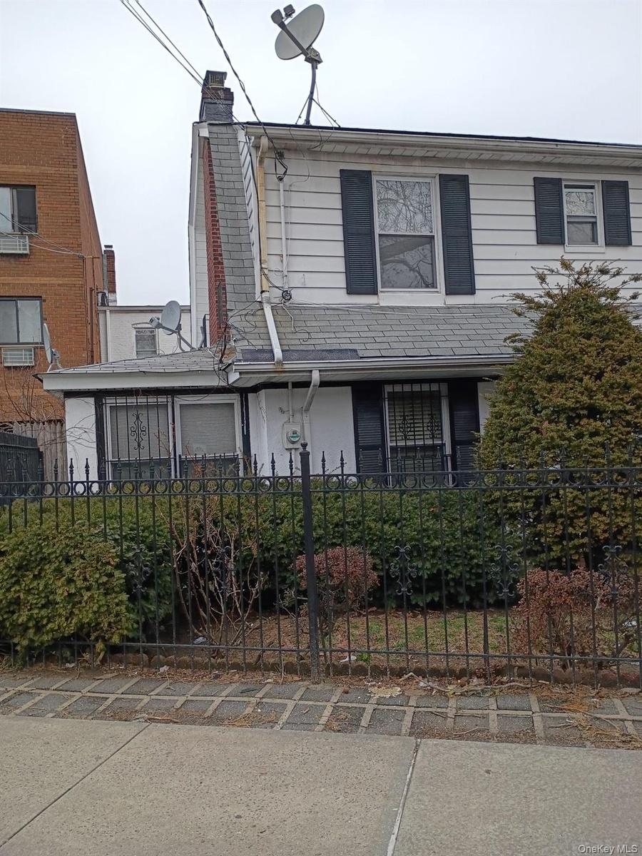 View of front facade featuring a fenced front yard and a chimney