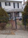 View of front facade with a fenced front yard and a gate