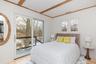 Bedroom with access to outside, multiple windows, and light wood finished floors