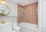 Full bath with tile walls, tiled shower / bath, vanity, and recessed lighting