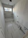 Full bathroom featuring shower / washtub combination and baseboards