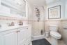 Full bath with tile walls, vanity, a shower stall, wainscoting, and light tile patterned floors