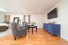 Living room featuring light wood-style floors, crown molding, and a skylight